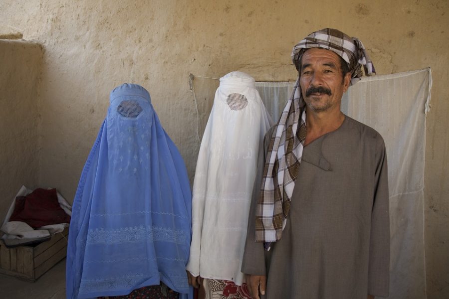 Een moslimman poseert met zijn twee vrouwen.