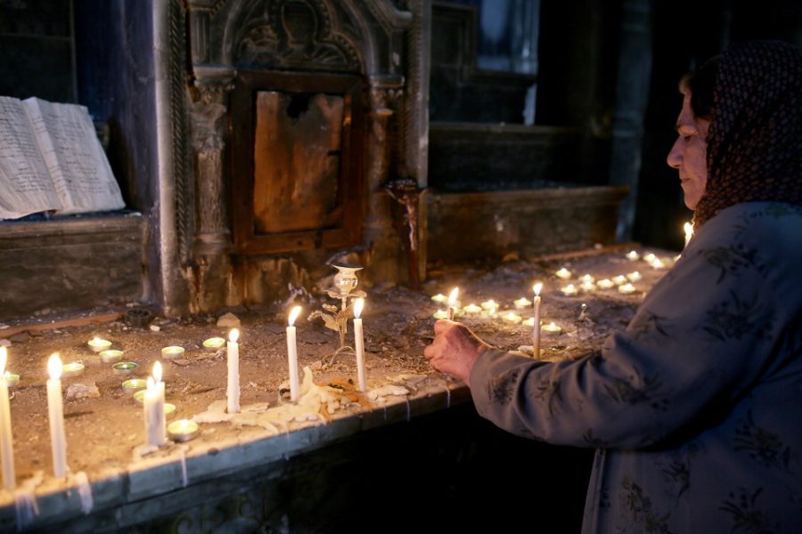 Irakese christenen branden kaarsen in de door IS verwoeste Al-Tahira kerk, na de
verdrijving van IS uit de stad.