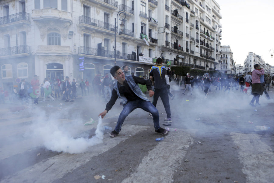 Een jonge Algerijn werpt een traangasgranaat terug naar de politie tijdens
protesten in Algiers, op 12 april 2019.