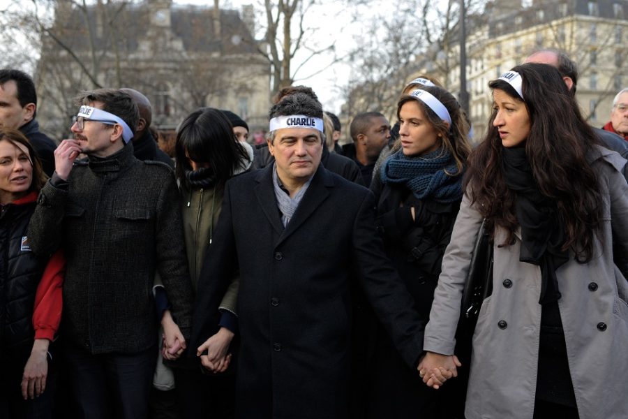 Medewerkers van Charlie Hebdo cartoonist Renald Luzier (Luz) (links), Spoedarts
en Charlie Hebdo columnist Patrick Pelloux (midden) en Charlie Hebdo journaliste
Zineb El Rhazoui verzamelen voor een mars tegen terrorisme in Parijs.