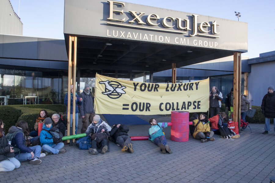 Extinction Rebellion activisten kleven zich vast aan mekaar voor de ingang van
een bedrijf dat privé-jets verhuurt in Zaventem.