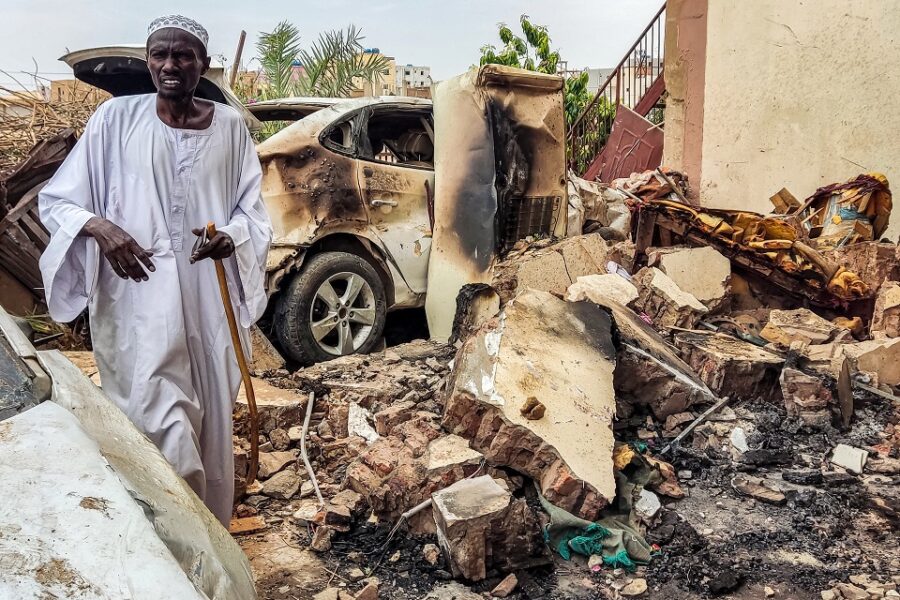 Een man bekijkt de schade aan huis en auto in Khartoem, Soedan, na
artilleriebeschietingen.