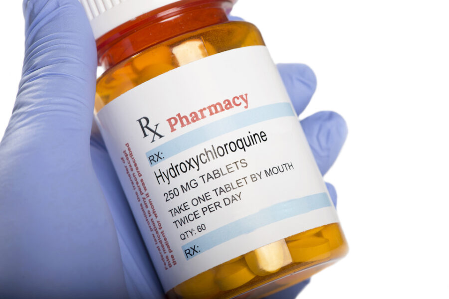 Generic drug hydroxychloroquine phosphate prescription bottle held by gloved
hand.
